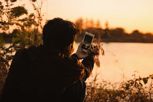 human man holding white smartphone photo