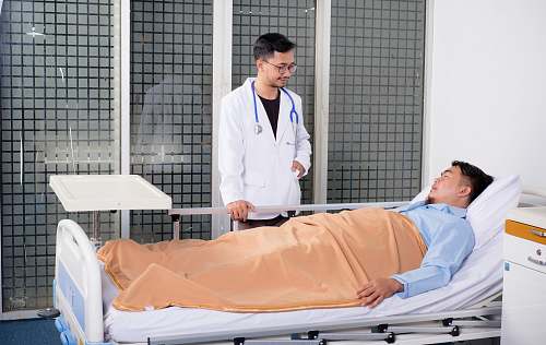 human man lying on bed talking to doctor people