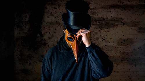 clothing man wearing long-nosed mask and black hat apparel