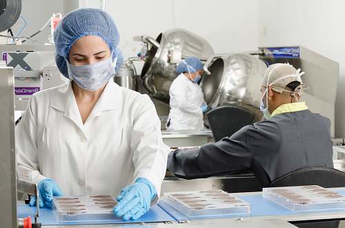human three people inside factory wearing masks and coats clinic