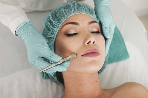 human woman doing liposuction on her face face