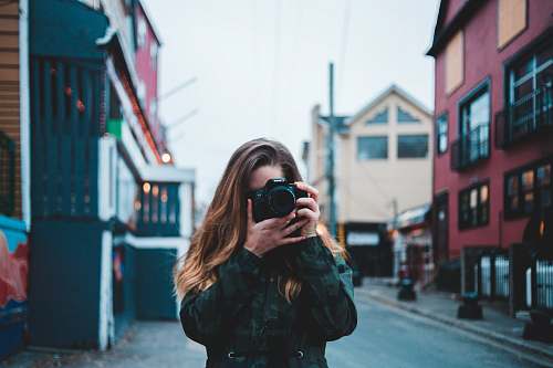 human woman taking photo using DSLR camera camera