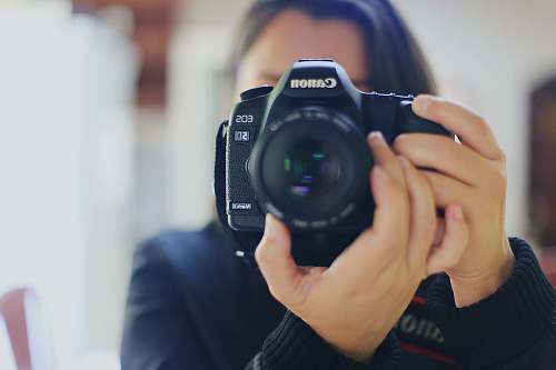 human woman using black Canon DSLR camera camera