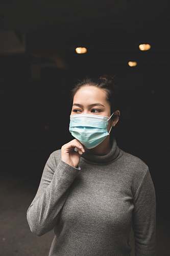 human woman wearing teal mask and gray turtle-neck shirt people