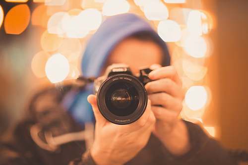 human man holding Canon DSLR camera person