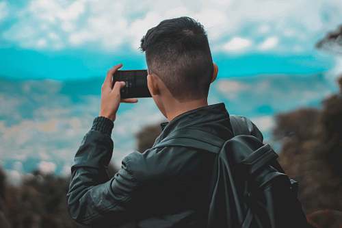 human person holding black smartphone person