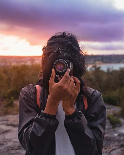 human person wearing black jacket taking picture using DSLR camera person