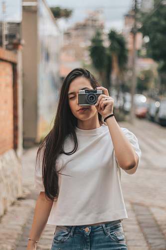 human woman holding black and gray bridge camera person