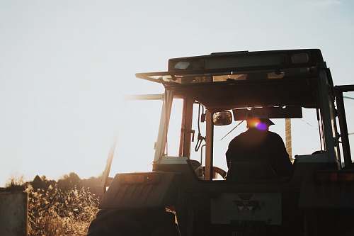 farming silhouette of man riding tractor agriculture