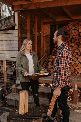  man and woman standing beside brown wooden fence 