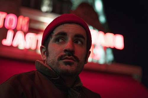 clothing man beside a red neon sign human
