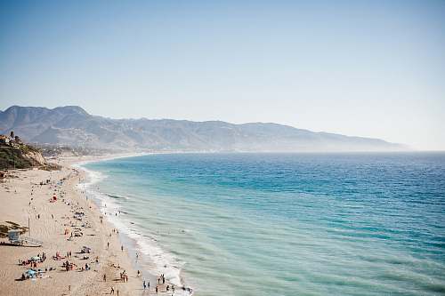 coast aerial view of beach with blue ocean water during daytime ocean