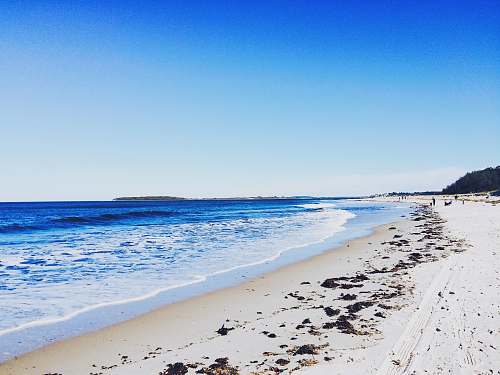 sea body of water beside white sands during daytime water
