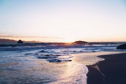 ocean body of water during sunset sand