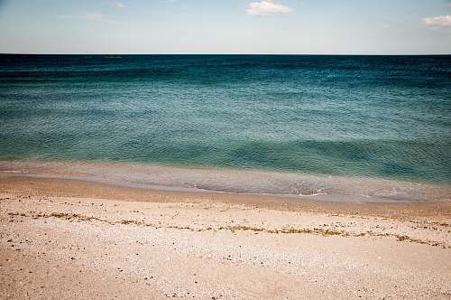 nature calm water of sea under blue and white sky during daytime photography water