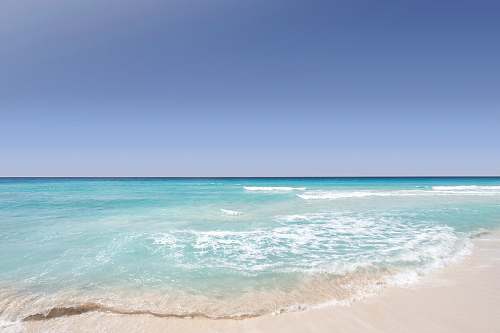 sea Clear blue ocean washing on the sandy shore on a clear day in Cancún ocean