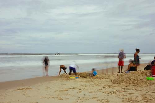 ocean group of people standing on beach shore sea