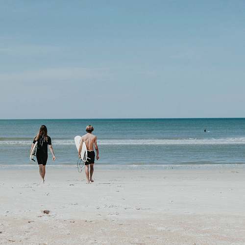 water two person walking on coast sea