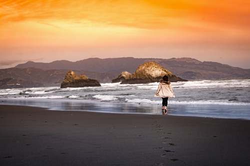 ocean woman wearing on seashore during sunset sea