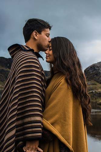 person man kissing woman on forehead human