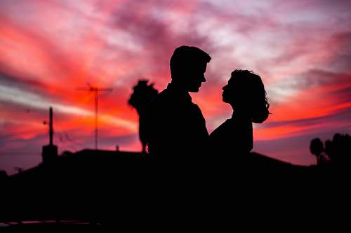sunrise silhouette of man and woman facing each other during golden hour sunset