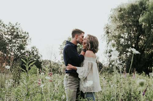 couple male and female kissing on grass field kiss
