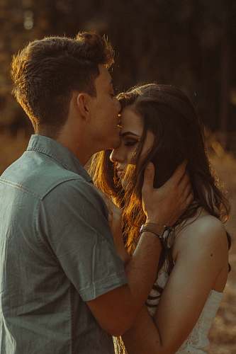 people man kissing woman forehead couple