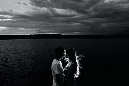 love grayscale photo of couples near body of water human