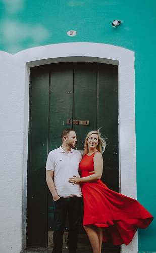 human man and woman standing near door during daytime person