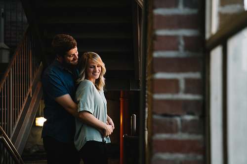 person man hugging woman from behind near stair human