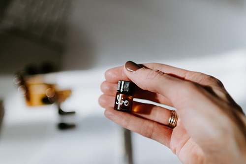 person person holding brown glass bottle finger
