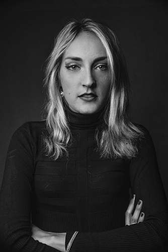human greyscale photo of woman in long sleeved shirt crossing hand face
