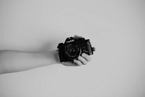 camera person holding a nikon camera body electronics