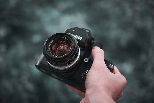 electronics person holding black Nikon DSLR camera photo