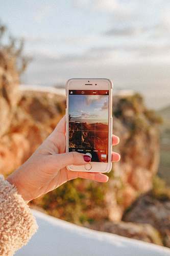 casares person taking a photo of scenery during sunset holding