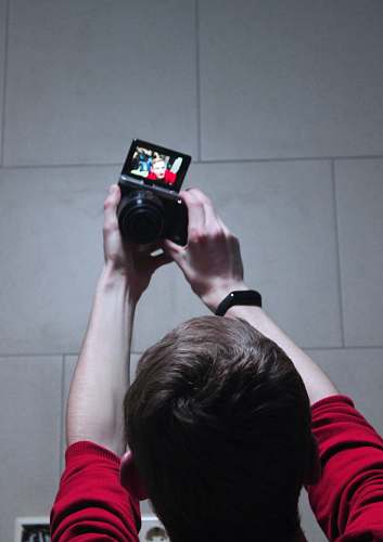 person close-up photography of man taking selfie camera