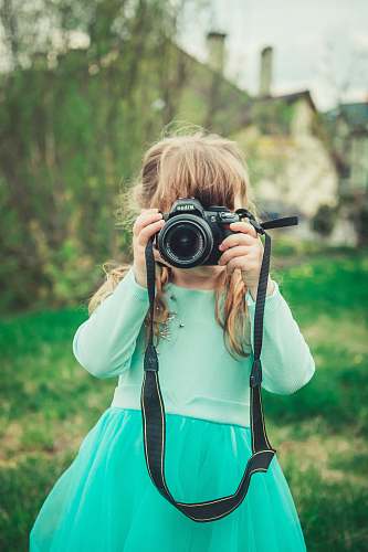 person girl holding black DSLR electronics