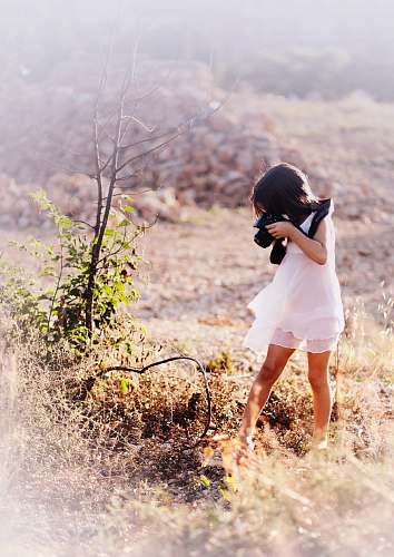 girl girl taking picture of tree branch outdoors people