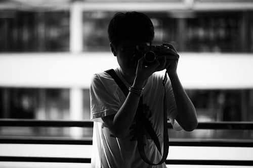 person grayscale photography of person holding camera black-and-white
