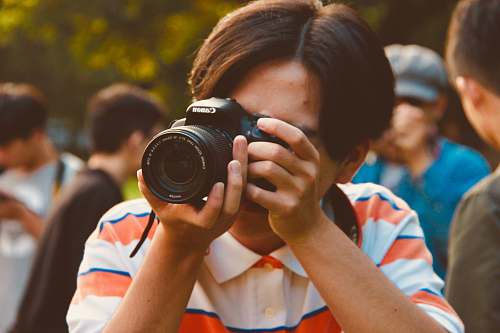 person man holding Canon camera camera