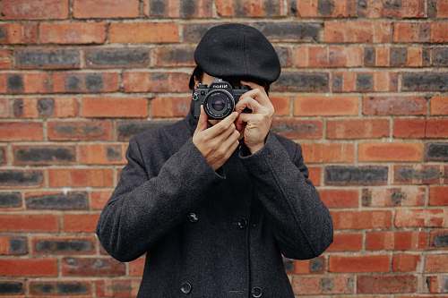 person man holding DSLR camera camera