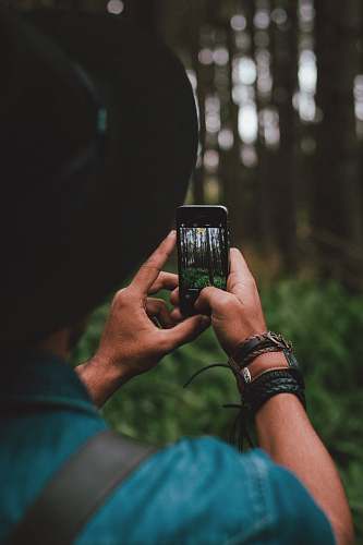 person man holding iPhone 5s forest