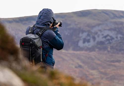 person man taking photo of mountain photography