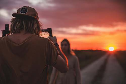 person man taking photo of woman on road photographer