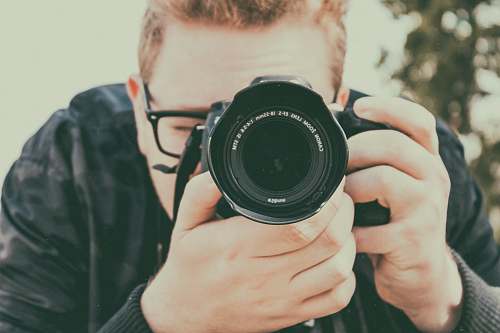 camera man taking photo using camera electronics