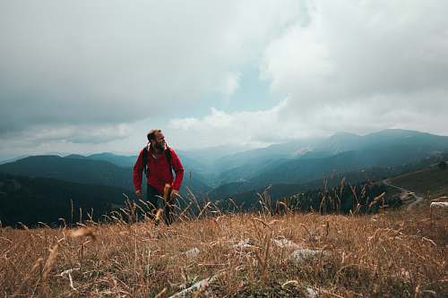 outdoors man wearing red jacket standing on the field nature