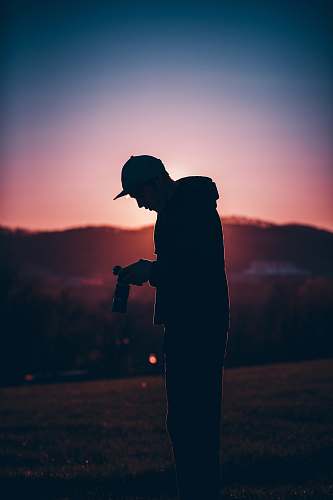 person silhouette of man holding camera silhouette