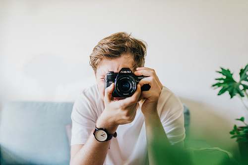 person sitting man taking picture camera