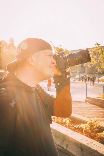 person unknown person holding black DSLR camera photo