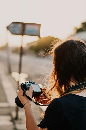 person woman holding DSLR camera photo